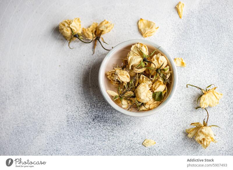 Dried roses in a bowl on a textured surface for decoration dried withered gray background beauty subtle grace nostalgic floral vintage elegant close-up petal