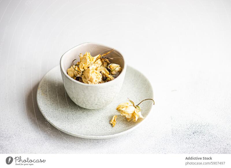 Dried roses elegantly displayed in a ceramic bowl dried plate texture arrangement decoration white background soft nature floral design home simplicity