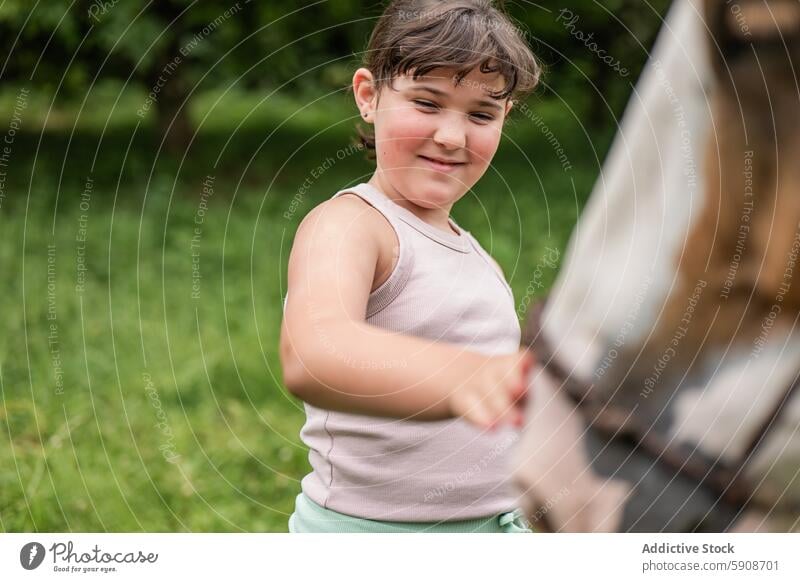 Young girl enjoying time with a horse outdoors interaction touching joyful happiness green nature child animal connection play gentle summer countryside farm