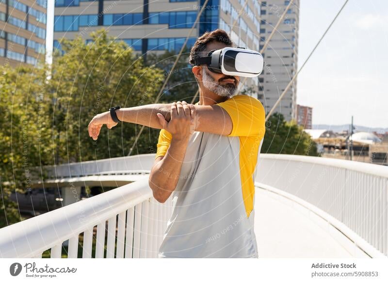 Man using virtual reality headset outdoors in sunny setting man indian city bridge stretching technology gadget summer sport urban fitness vr exercise active