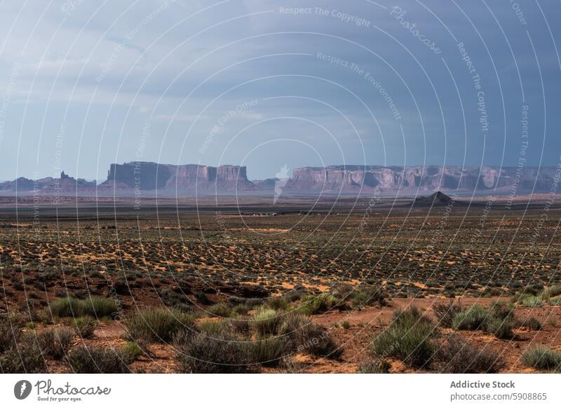 A storm approaches the rugged landscape of Monument Valley monument valley desert butte sandstone arid plain sky dark dramatic nature outdoor scenic vast mesa