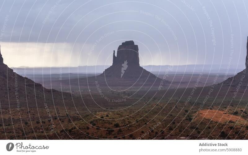 Storm over the iconic hills of Monument Valley monument valley storm rain butte landscape rugged sky moody nature outdoor dramatic scenic view desert travel