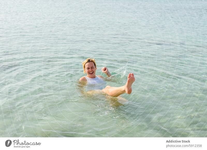 Joyful woman playing in clear waters at an Italian beach splash summer vacation sea italian joy cheerful swim crystal-clear serene blissful sunny leisure