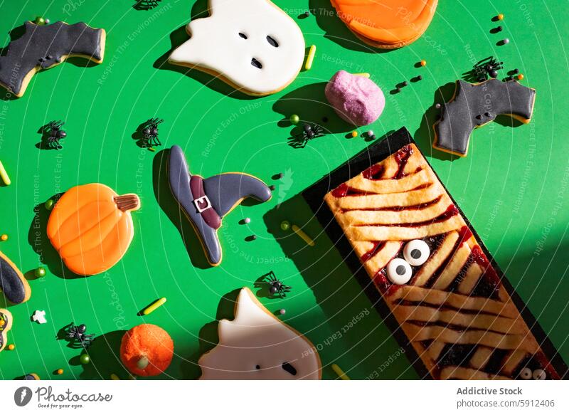 Festive array of homemade Halloween-themed cookies halloween ghost bat pumpkin witch hat background green colorful celebration festive dessert treat baking