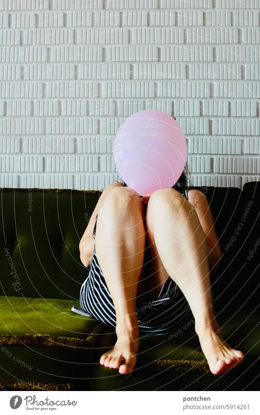 woman sits on a green sofa and hides her face behind a pink balloon Hide Anonymous oust Balloon Woman Sofa vintage Dress Green Style Feminine Adults