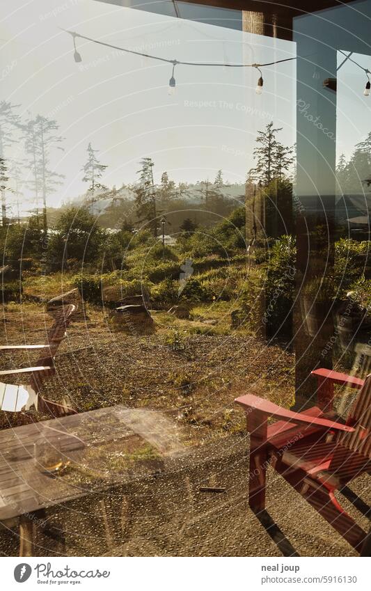 View through the reflective pane over a terrace onto the coast of Western Canada vacation house by the sea Terrace outlook Nature naturally Untouched Calm