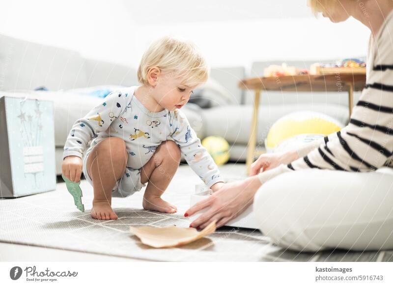 Parents playing games with child. Little toddler doing puzzle. Infant baby boy learns to solve problems and develops cognitive skills. Child development concept