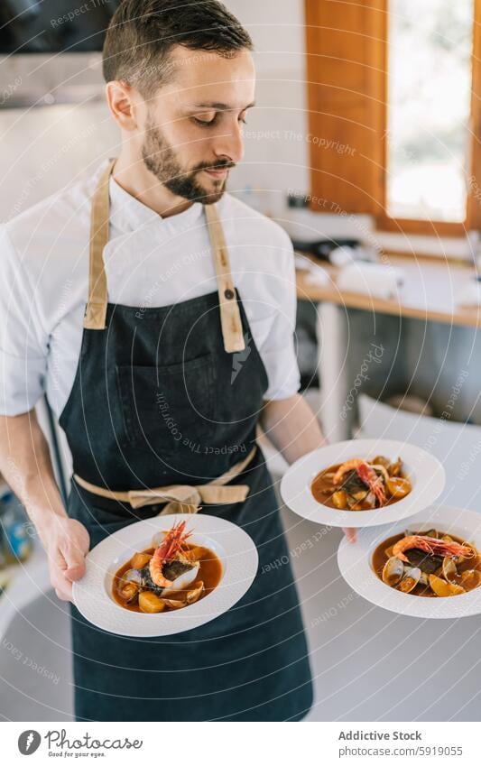 Private chef serving seafood dishes in a modern kitchen private chef plate gourmet apron service sunlit focus professional culinary cooking preparation