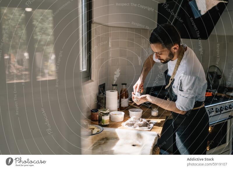 Private chef preparing fresh fish fillets in a sunlit kitchen private meal preparation cooking food window culinary expertise concentration looking down indoor