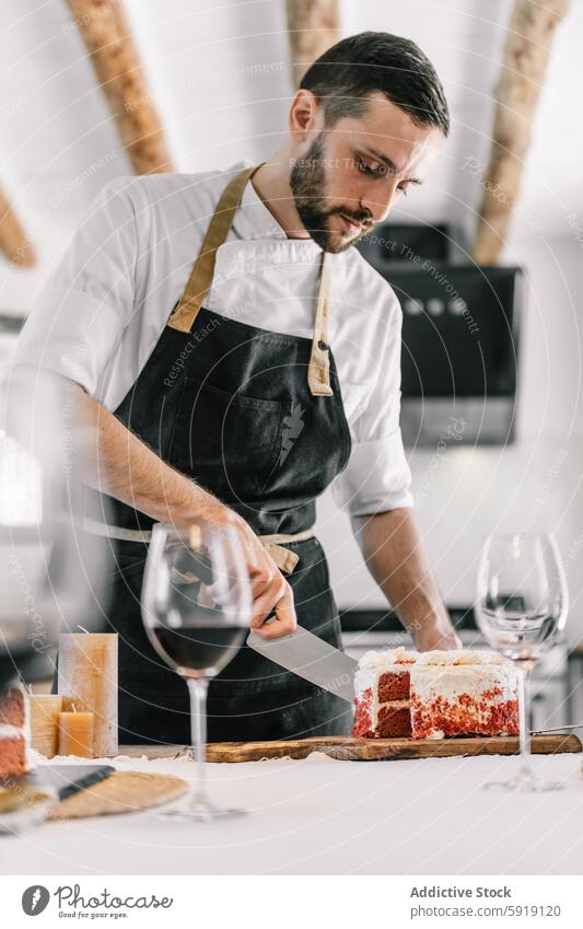 Private chef slicing cake in kitchen with focus and precision private chef male modern professional white shirt dark apron culinary arts food preparation