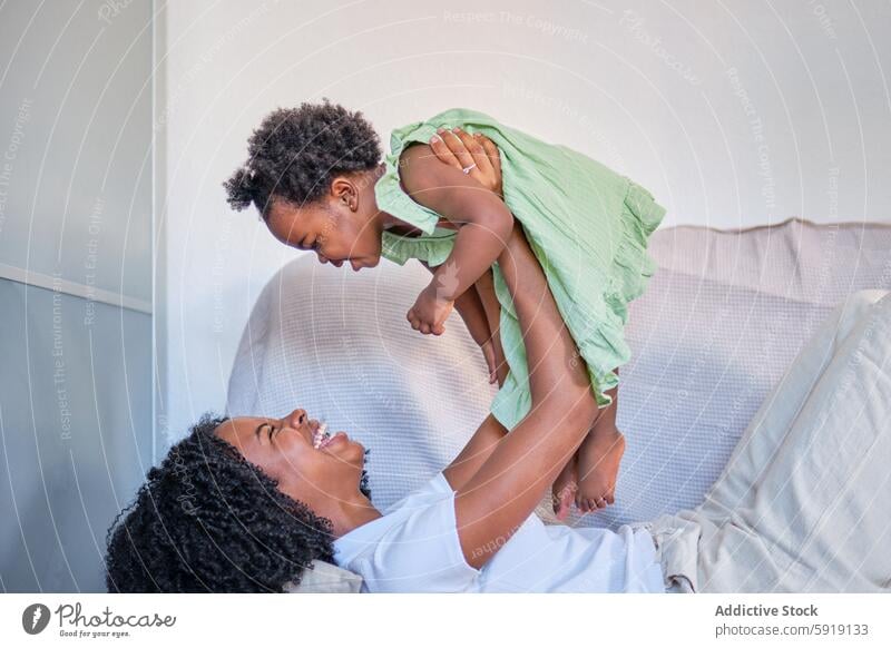 African American mother and daughter sharing a joyful moment african american black ethnic family love bonding home smile happiness parent child woman girl