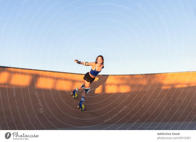 Young female roller skater enjoying sunset in skate park girl trick young roller skating skateboarding sport active activity outdoor exercise fun skate-park