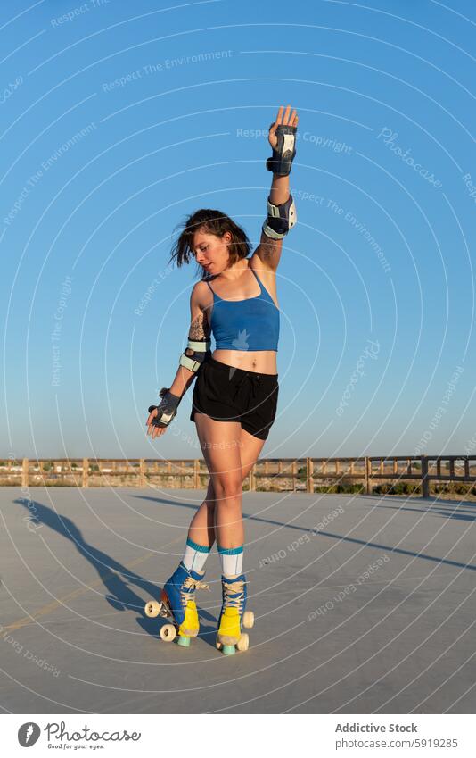 Young woman roller skating at park during sunset skate park blue sky active outdoors fitness summer sport recreation activity youth leisure lifestyle exercise