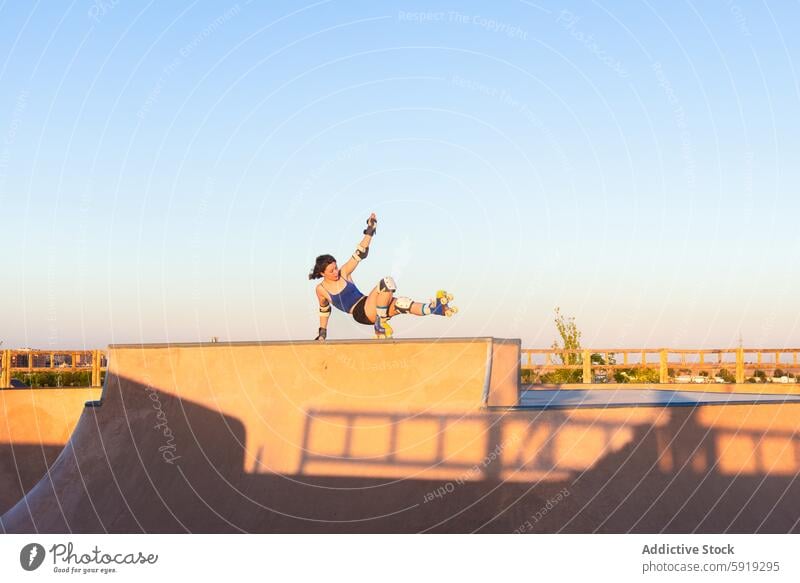 Young woman performing a trick on roller skates at sunset girl skate park stunt sport activity outdoor young athletic performance motion youth recreation