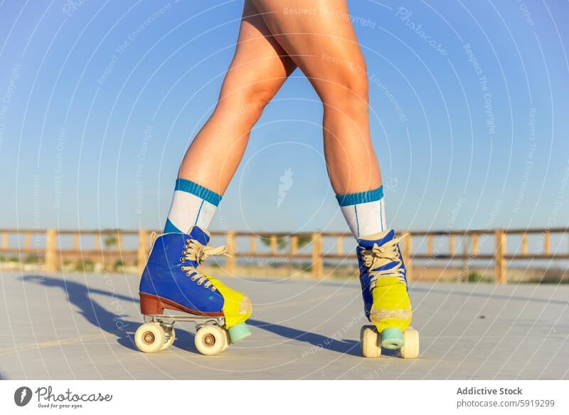 Young girl roller skating in a sunny park roller skate skate park outdoor youth activity motion dynamic close-up leg footwear colorful movement energy