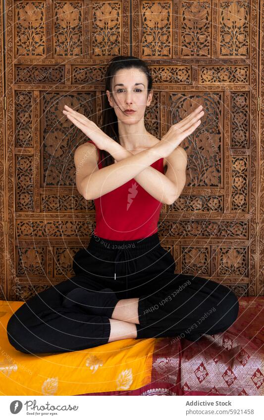 Woman practicing yoga in front of a carved wooden screen woman pose detail colorful mat meditation relaxation fitness wellness health inner peace concentration