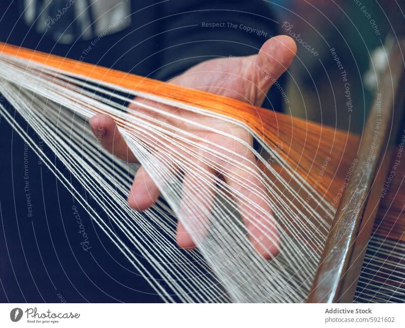 Hands weaving on a loom in textile workshop hand close-up thread craft yarn fabric manual skill artisan production textile industry textile manufacturing