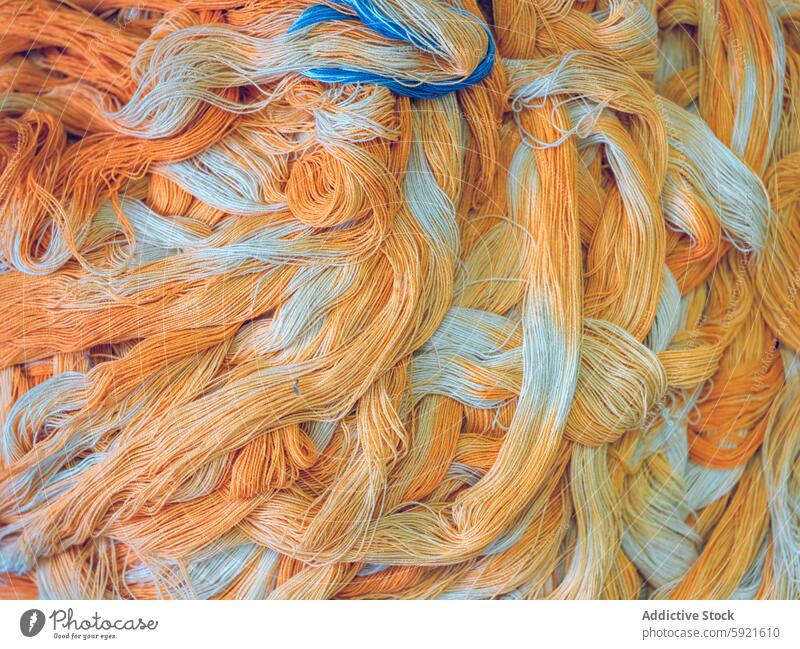 Close-up texture of colorful yarn bundles in factory setting orange blue intertwined close-up assortment vibrant fabric material thread textile industry