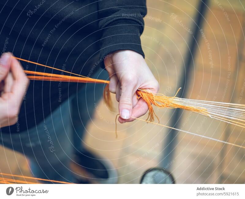 Factory worker handling threads in a yarn production setup factory textile orange anonymous craftsmanship industry material manufacturing process unrecognizable