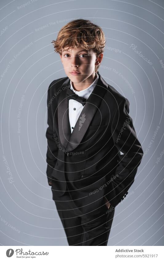 Preteen boy wearing elegant suit and bow tie looking at camera in studio kid classy confident preteen child style tuxedo formal outfit hands in pocket