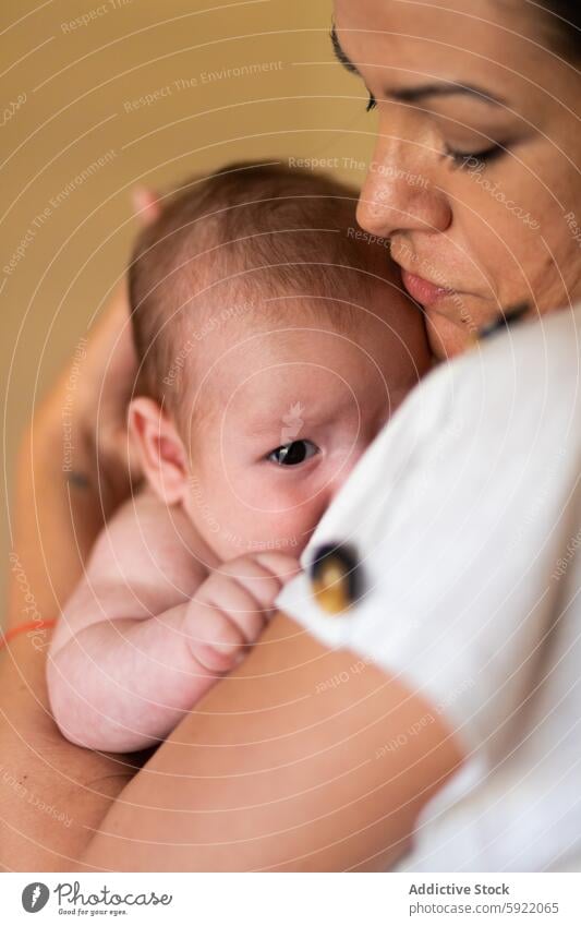 Loving mother hugging newborn at home woman embrace baby caress motherhood babyhood love tender together affection female young stroke calm parent mom harmony