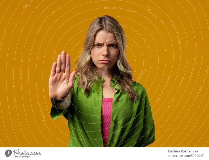 Uninterested woman disapproving with NO sign gesture. Denying, rejecting, enough female hand palm stop warning adult background girl studio young denial refusal