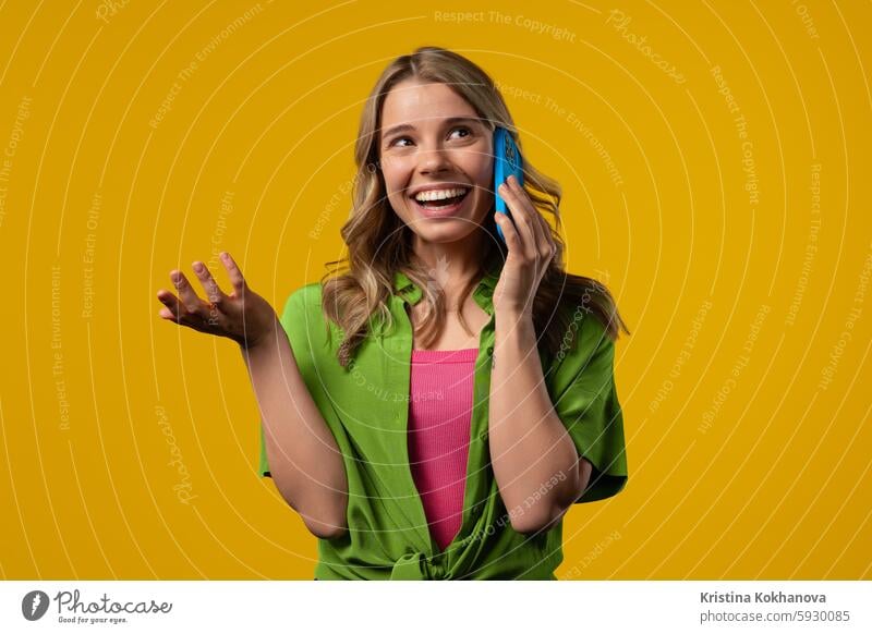 Attractive woman talking by phone, smiling. Young lady on yellow background answering beautiful ask information attractive business call cell calling