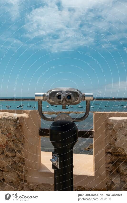 A tourist binocular is installed at a scenic viewpoint, offering a panoramic view of the sea in Cadiz, Andalusia, Spain. cadiz andalusia castle stunning