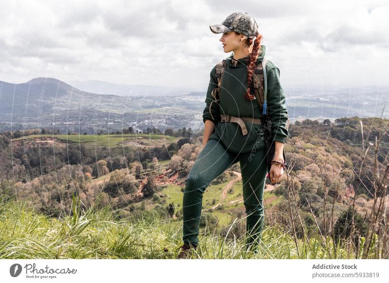 Female hiker enjoying scenic mountain view woman nature landscape outdoor adventure trekking exploring green attire caucasian female backpack looking away grass