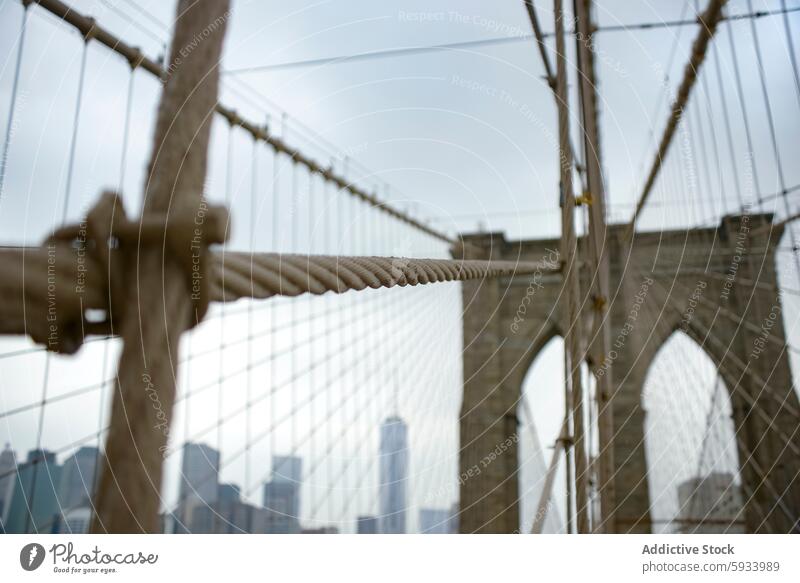 Close-up view of Brooklyn Bridge's cable with Manhattan backdrop brooklyn bridge manhattan skyline new york architecture landmark urban cityscape structure