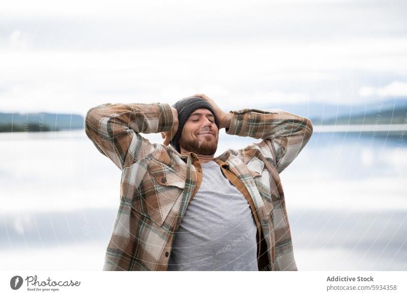 Relaxed man enjoying nature by a serene lake relaxation happiness tranquility peaceful outdoor camping water leisure adult male young casual freedom lifestyle