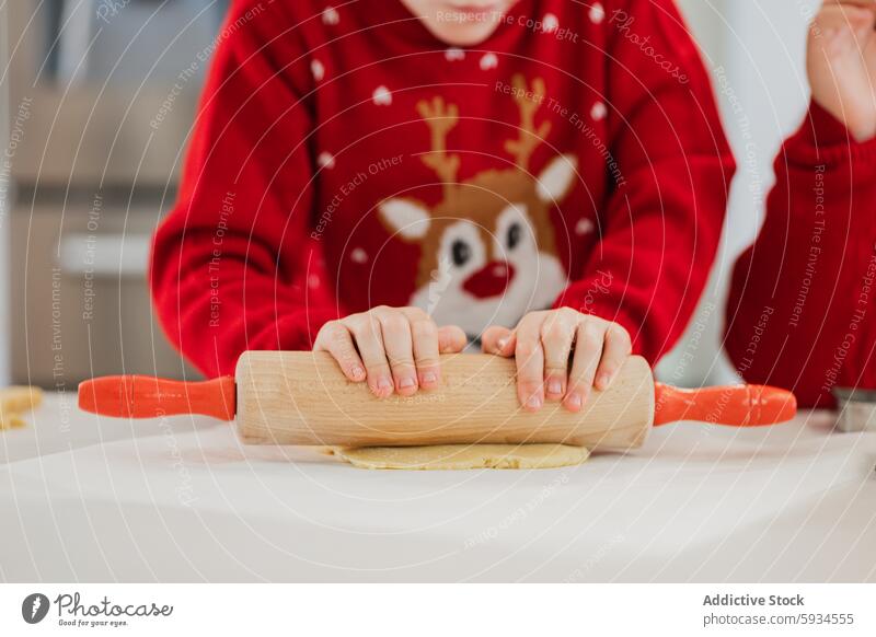 Twins baking during Christmas in festive sweaters twin child christmas dough kitchen holiday reindeer cooking countertop flour rolling pin celebration family