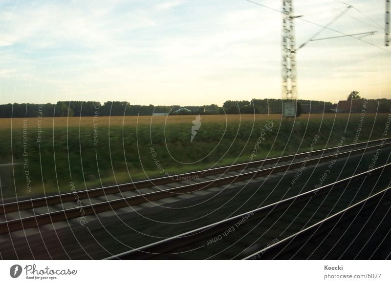 Rails in the countryside Railroad Railroad tracks Field Tree Electricity pylon Gravel Silo Clouds Transport Train station Stone Sky