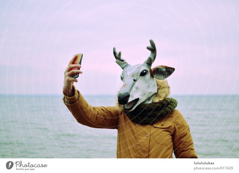 It's a reindeer. Carnival Human being Feminine Face 1 Nature Sky Beach Ocean Jacket Mask Animal Reindeer Smiling Stand Happiness Large Hip & trendy Joy