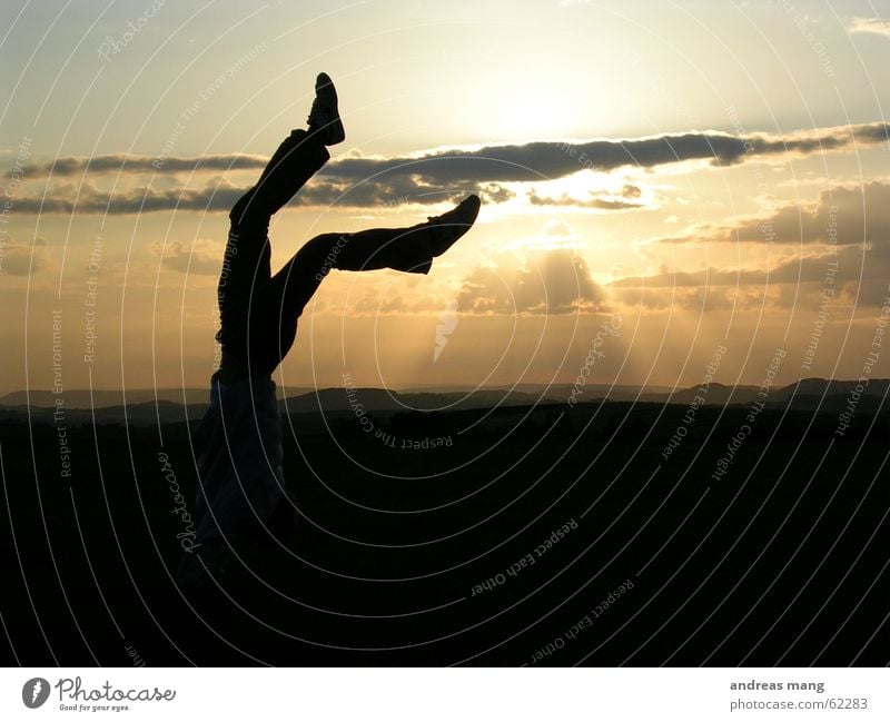 Walking on sunshine Handstand Footwear Sunset Dusk Clouds Horizon Sunbeam To enjoy Man Feet foot shoe walking Legs leg cloud Mountain Landscape Lighting evening