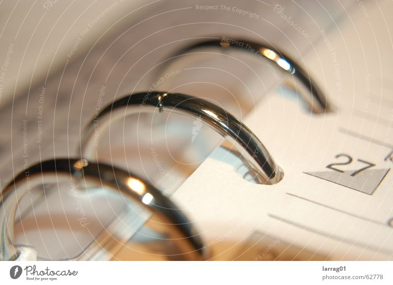 time is relative Calendar Macro (Extreme close-up) Detail Section of image Metal ring Chrome Digits and numbers Planning Management Business Loose-leaf