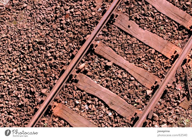 three materials Railroad tracks Transport Wooden board Gravel Sunlight Evening sun Light Deep Wanderlust Right ahead Passenger train Freight train