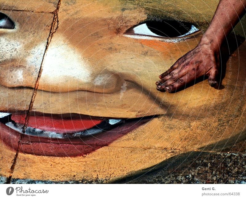 Street painting, portrait of a baby face on stone slabs with the artist's hand in the picture Hand Asphalt Evil Red Black Painting and drawing (object) Art