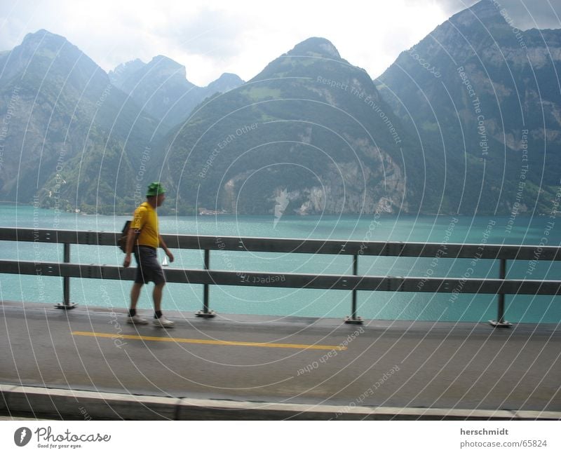 mountain tour Lake Man Yellow Going Backpack Sidewalk Cap Mountain Water Street Sky