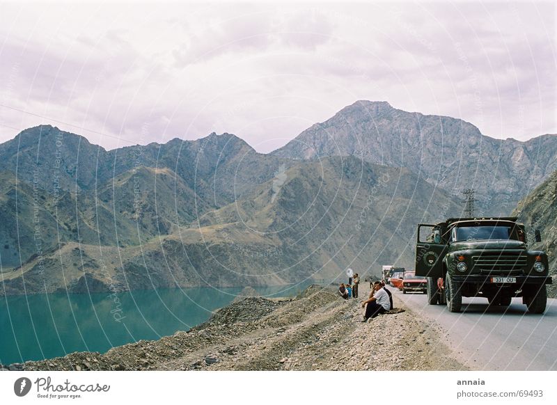 picnic Colour photo Exterior shot Day Picnic Joy Mountain To talk Water Lake Street Truck Wait landslide hills break waiting talking