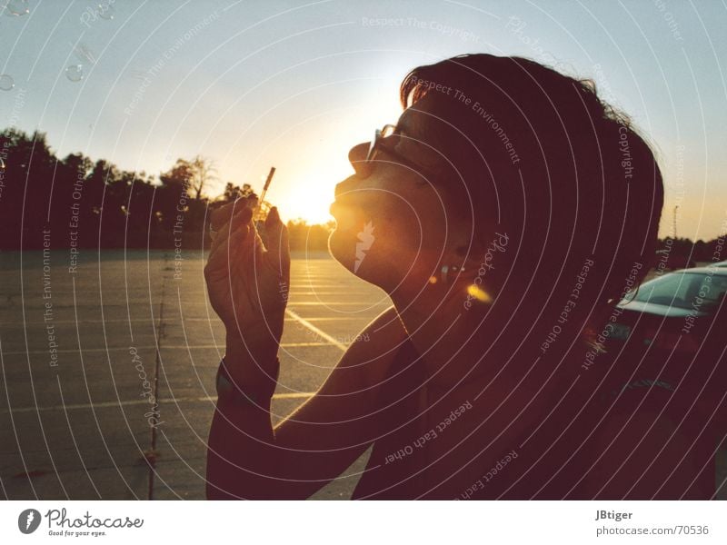 flashback Soap bubble Blow Feminine Summer Evening sun Parking lot Eyeglasses Sleeveless t-shirt Exterior shot Sunbeam Think Physics Sunset Breathe Calm Dream