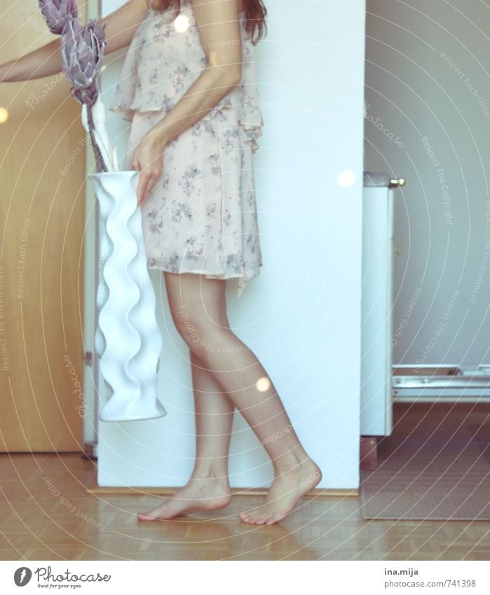 young woman walks through the room carrying a big white vase with artificial flowers Human being Feminine Young woman Youth (Young adults) Woman Adults 1