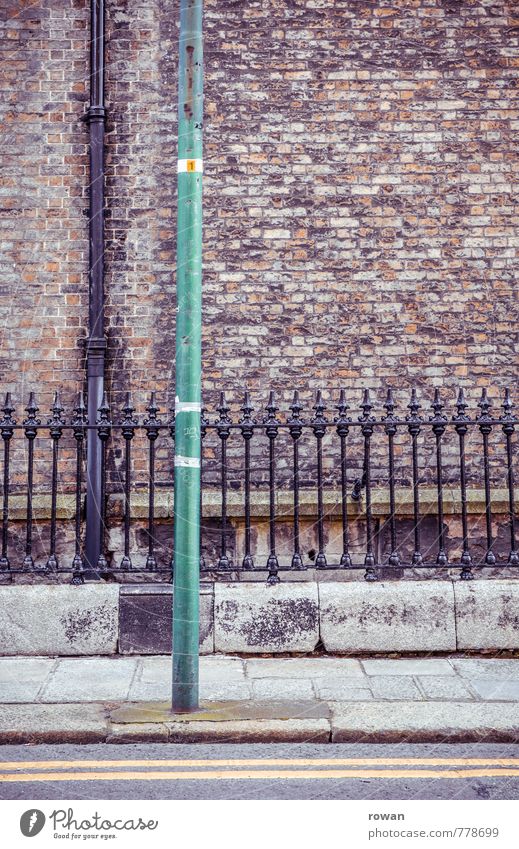 || Wall (barrier) Wall (building) Old Fence Cast iron Downpipe Street Sidewalk England Ireland Brick Brick wall Colour photo Exterior shot Deserted