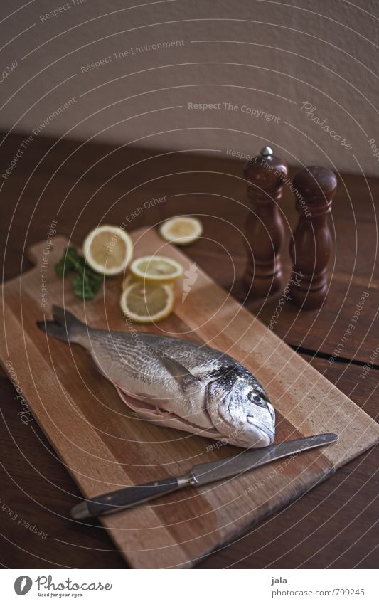 fish Food Fish Dorade Lemon Cooking salt Pepper Nutrition Knives Chopping board Healthy Eating Fresh Delicious Natural Appetite Wooden table Colour photo