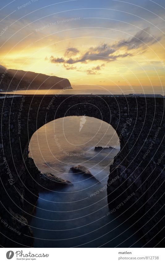 bridging day Water Sky Clouds Horizon Sunrise Sunset Spring Weather Beautiful weather Hill Rock Waves Coast Ocean Bridge Blue Gold Gray Madeira Colour photo