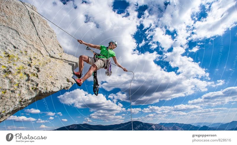 Climber rappels over the edge. Adventure Climbing Mountaineering Success Androgynous 1 Human being 30 - 45 years Adults Clouds Helmet Self-confident Brave