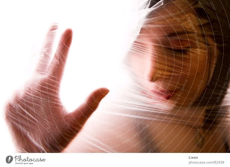 Thoughts in foil Dark-haired Packing film Woman Hand Back-light Emotions Young woman Think Absentminded Fear Panic Grief Distress Face be lost in thought