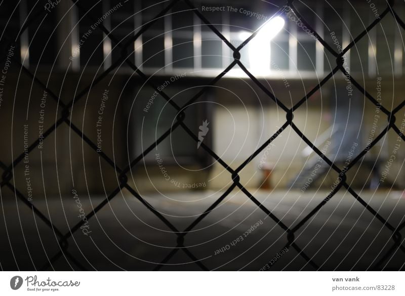 cross-linked Grating Fence Closed Light Lamp Exposure Asphalt Wire Wire netting Window Night Dark Cold Ashtray Loneliness Grief Wall (building) Wall (barrier)