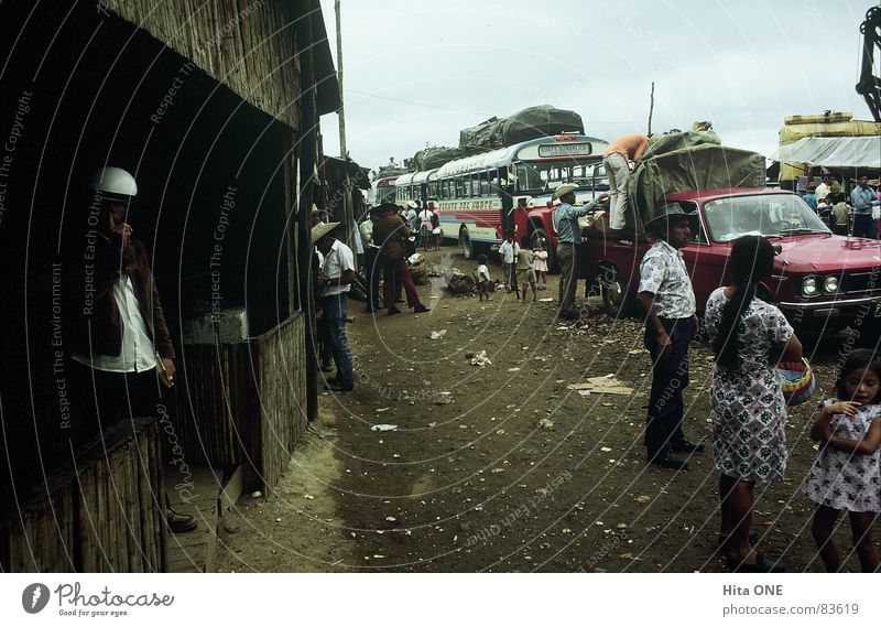 finally. Delivery truck Man Woman Sidewalk Dirty Dress Wooden hut Dark Helmet Gesture Pathetic Poverty Disgust Bad weather South America queue of cars Stand