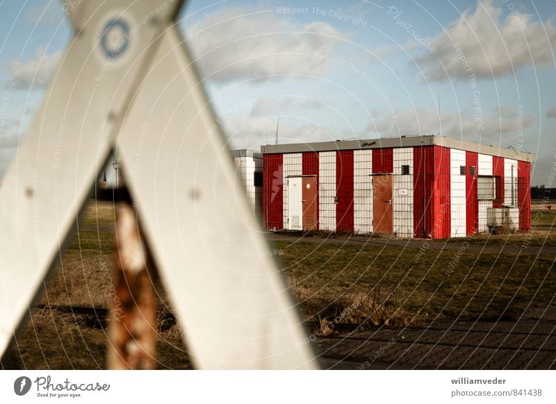 St. Andrew's cross in front of striped building Sky Park Airport Building Tourist Attraction Airfield Blue Green Red White Colour photo Exterior shot Deserted